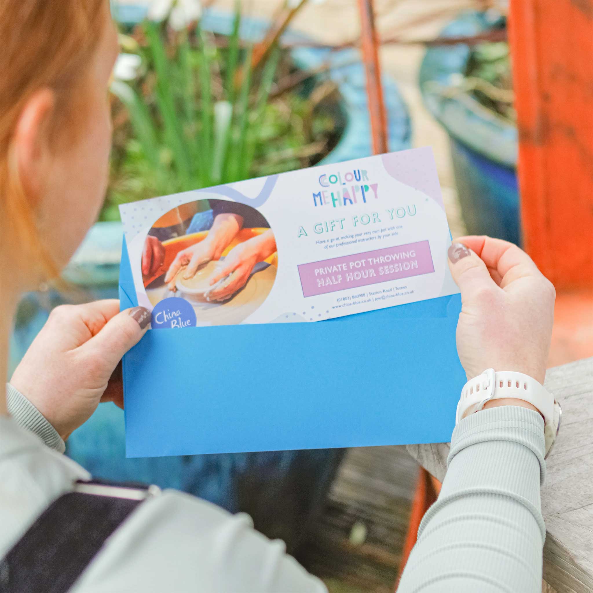 Lady opening a Pot Throwing Gift Voucher from China Blue