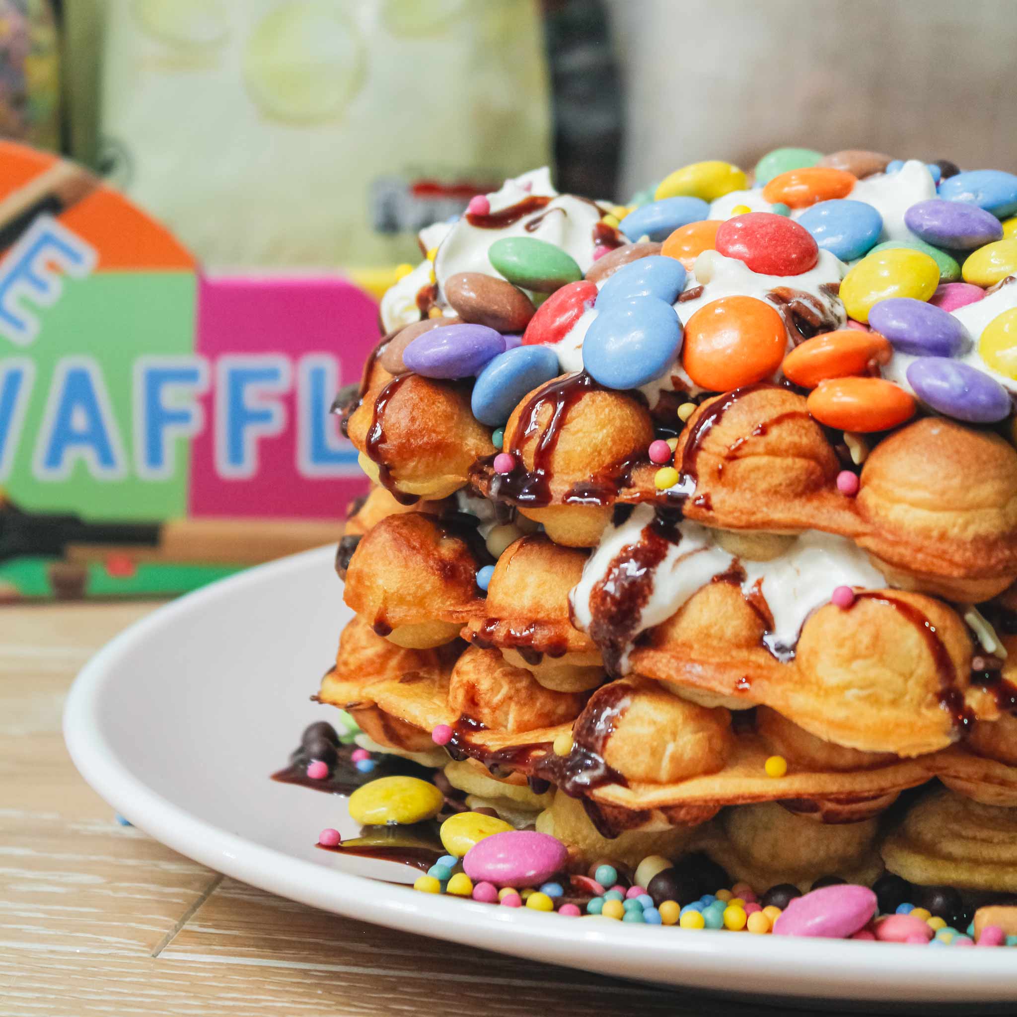 Huge bubble waffle topped with smarties and sprinkles by china blue
