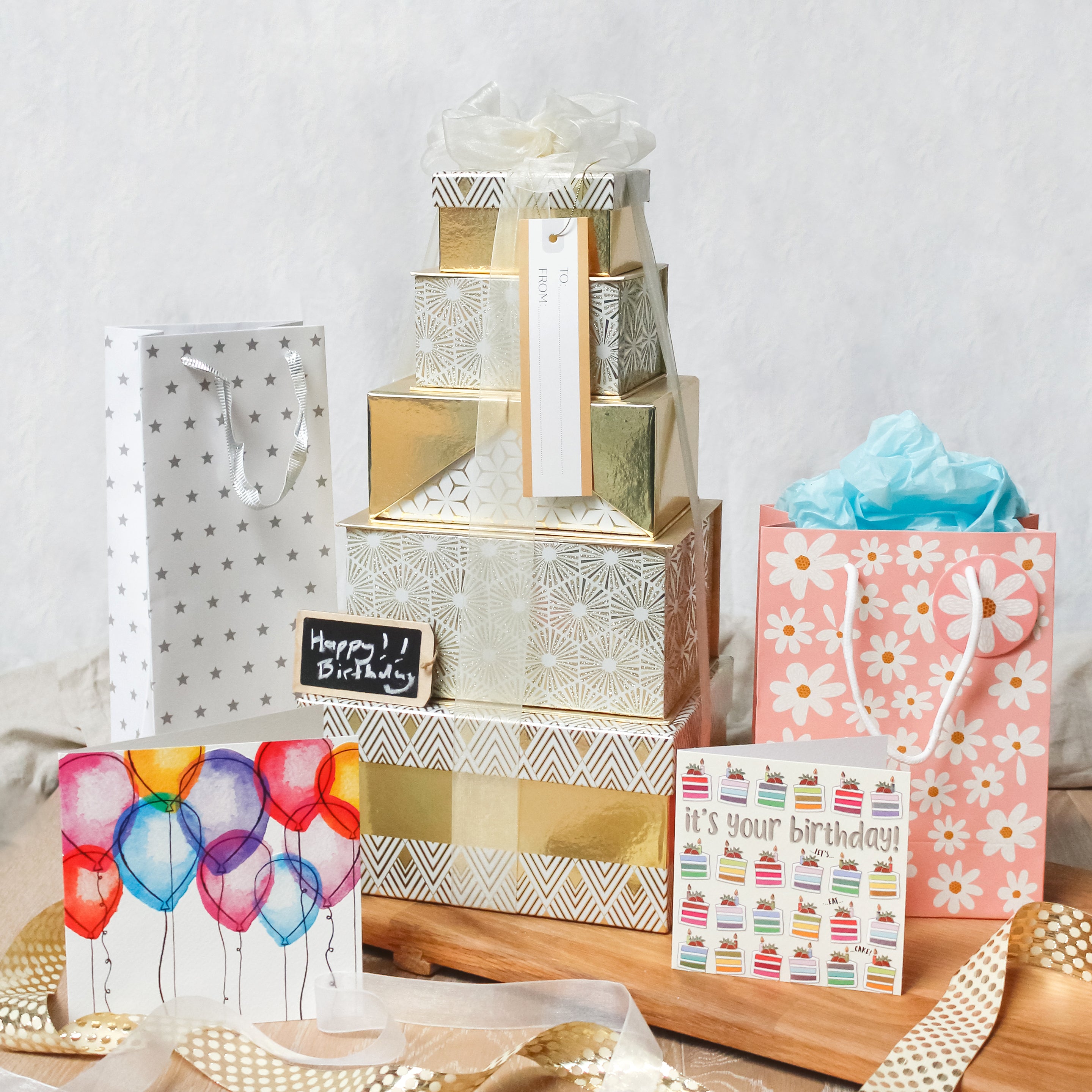 A white and gold sparkly box stack with birthday gifts