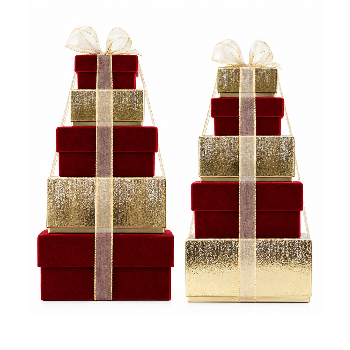 Two decorative gift box towers on a white background, each made of stacked rectangular boxes in deep red velvet and metallic gold, tied with sheer champagne-gold ribbons and bows.